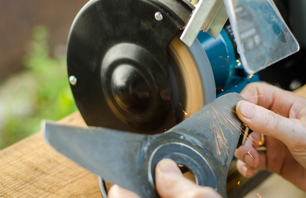 Sharpening your tools – like a lawn mower blade – makes the work go easier. Luckykot/Shutterstock.com