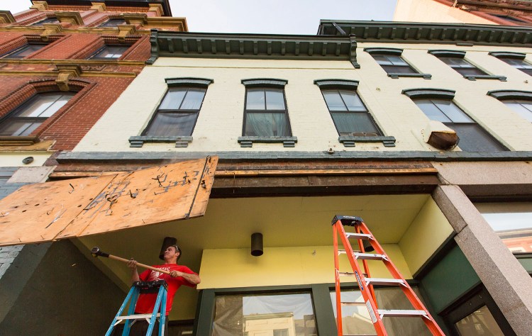 Josh Duball, a worker for Class Acts Property Management, demolishes the last remnant of the Paul's Food Center sign at 585 Congress St. on Tuesday. Portland Flea-for-All plans to open at the location Oct. 6.
Ben McCanna/Staff Photographer