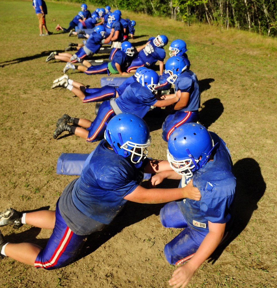 Staff photo by Joe Phelan 
 Members of the Oak Hill football team run through drills Tuesday during practice in Wales. The Raiders lost some key players to graduation but should once again be in the thick of Campbell Conference D.