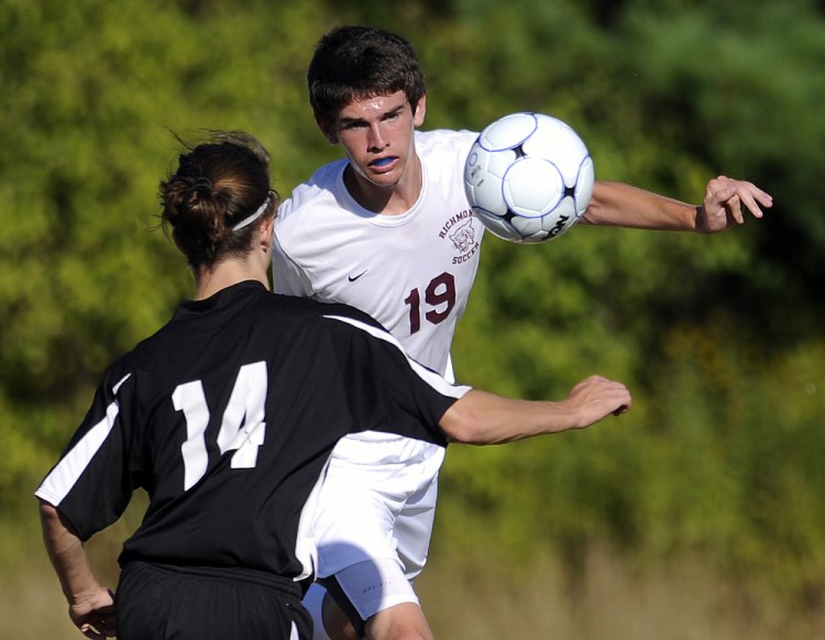 Richmond's Justin Vachon (19) knocks the ball past St. Dominic's Kyle Welsh during a game Monday in Richmond.