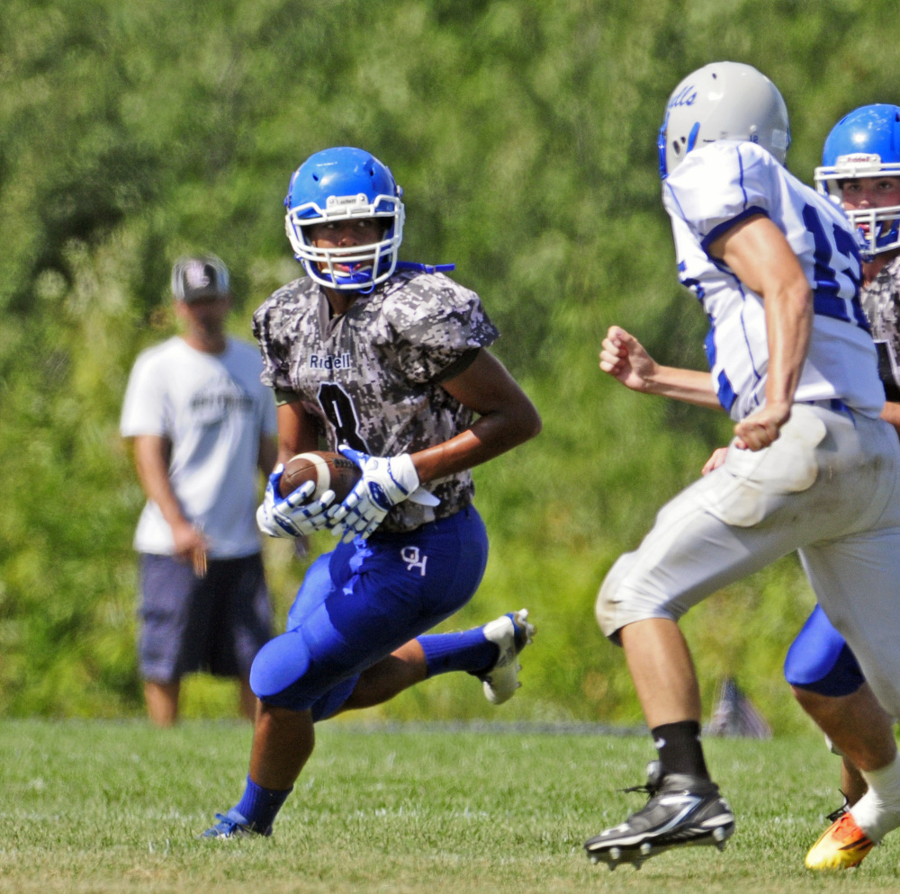 Oak Hill running back Darryn Bailey, left, runs around Old Orchard Beach defender Tyler Braiser during a game Saturday in Wales.