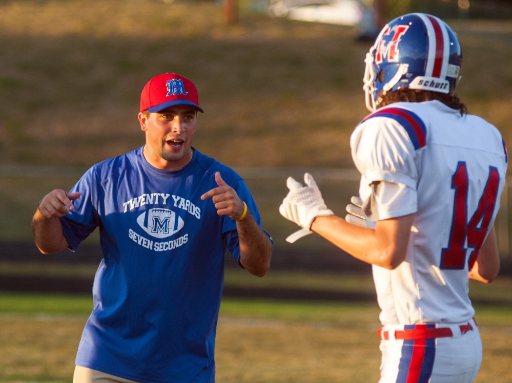 Messalonskee assistant football coach Kyle Bishop talks to Zak Bickford during warmups for a Pine Tree Conference Class B game against Cony last Friday at Alumni Field in Augusta.