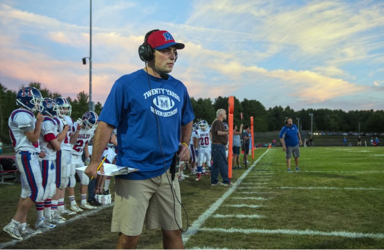 Messalonskee assistant football coach Kyle Bishop talks to another coach through his headset during a Pine Tree Conference Class B game against Cony last Friday at Alumni Field in Augusta.