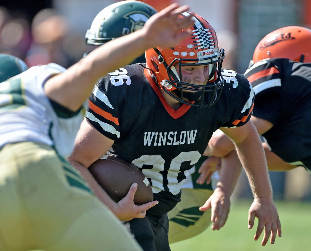 Staff photo by Michael G. Seamans 
 Winslow running back Kenny Rickard (36) runs through the Mount Desert Island defensive line Saturday in Winslow.