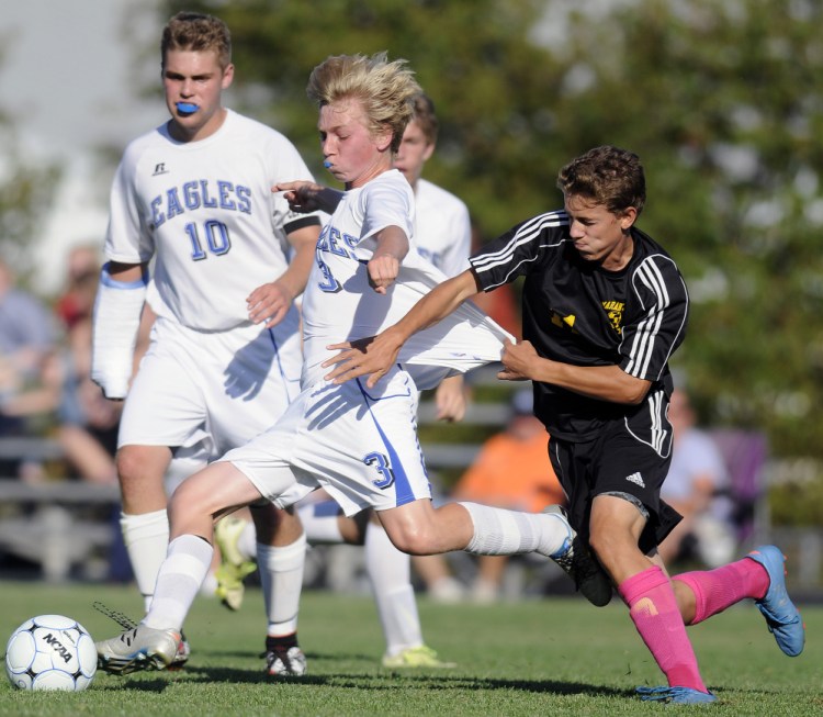 Maranacook junior forward Connor Stockwell, right, holds onto Erskine junior Caleb Tyler during a Class B game Tuesday in South China.