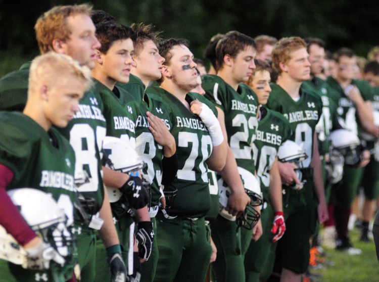 Members of the Winthop/Monmouth football team stand during the national anthem prior to a Campbell Conference Class D game against Dirigo last Friday at Maxwell Field in Winthrop.