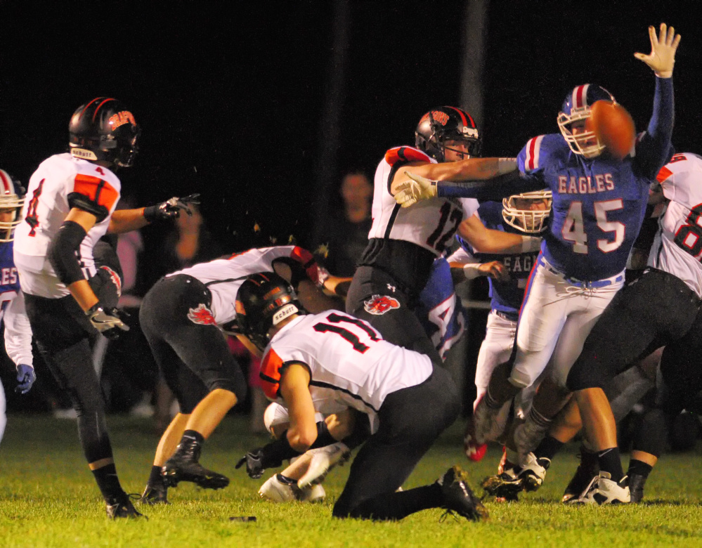 Messalonskee's Yan Gusmanov, right, tries to block an extra point attempt by Brunswick's Aaron Carlton during a game Friday at Veterans Field in Oakland.