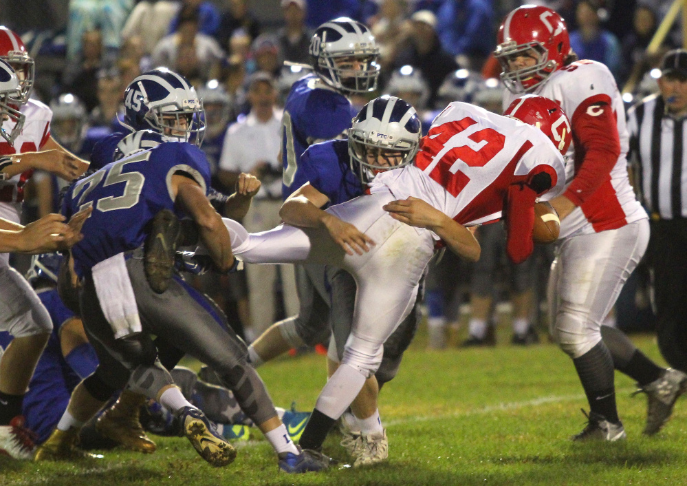 Lawrence defender Nicholas Denis, center, wraps up Cony's Jason Barnes with help from Riley Parlin (25) during the first half of a Pine Tree Conference Class B game in Fairfield on Friday night.