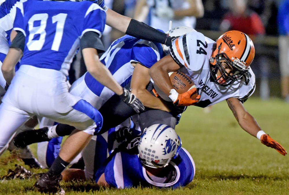 Winslow running back Keanu Earle (24) dives for extra yards as a host of Madison tacklers converge during a Big Ten Conference game Friday night in Madison.