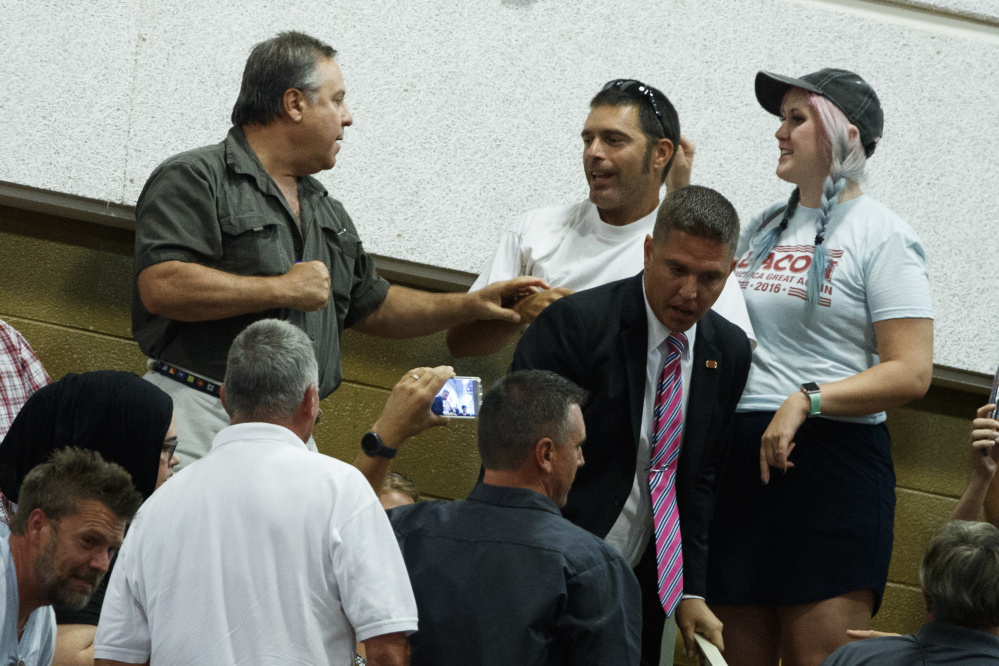 An unidentified man, left, confronts a demonstrator during remarks by Republican presidential candidate Donald Trump during a rally, Monday, Sept. 12, 2016, in Asheville, N.C. (AP Photo/Evan Vucci)