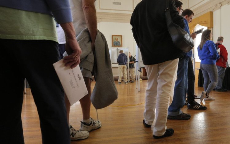 Voters wait in line as others cast their ballots at Portland City Hall on Tuesday, the first day of early voting for the Nov. 8 elections.