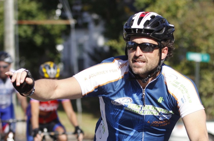 Patrick Dempsey waves a fans cheering along Elm Street in Mechanic Falls during the Dempsey Challenge in October 2011.