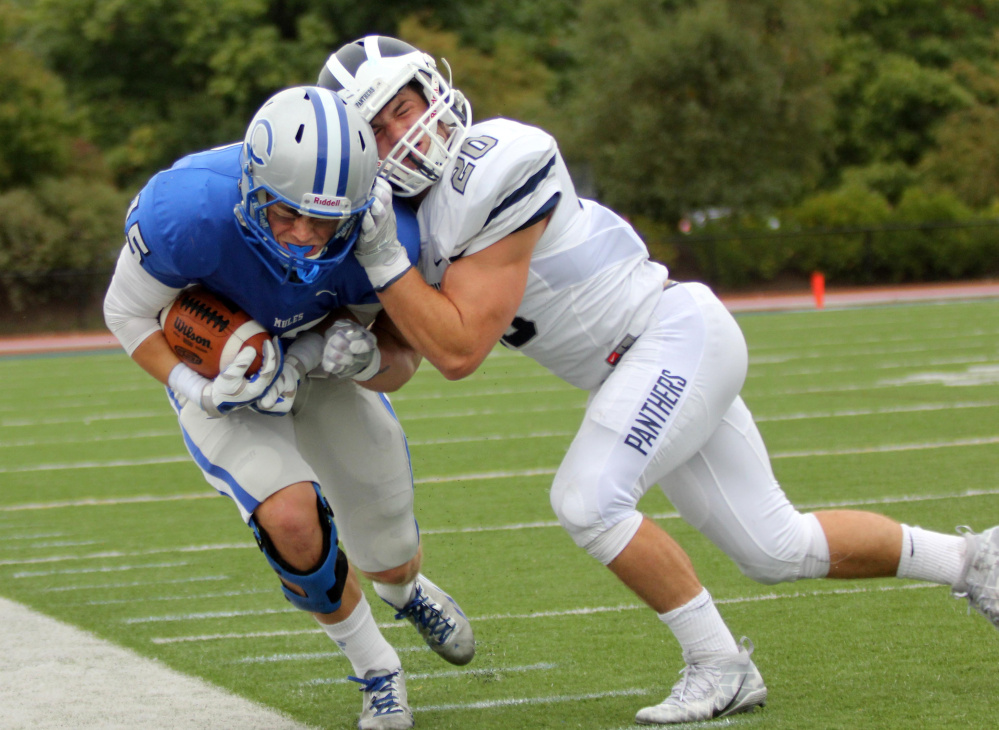 Colby College wide receiver Ryder Arsenault gets knocked out of bounds by Middlebury College's Justin Fahey after catching a pass from quarterback Jack O'Brien during first-half action Saturday in Waterville.