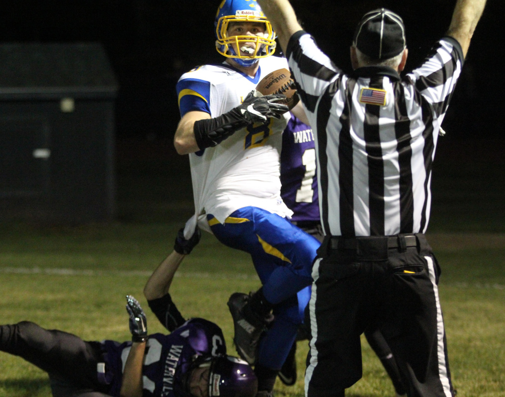 Belfast receiver Tristan Roberts looks at a referee after scoring a touchdown as Waterville defender Kody Vallee hangs on during first-half action at Drummond Field on Friday night.