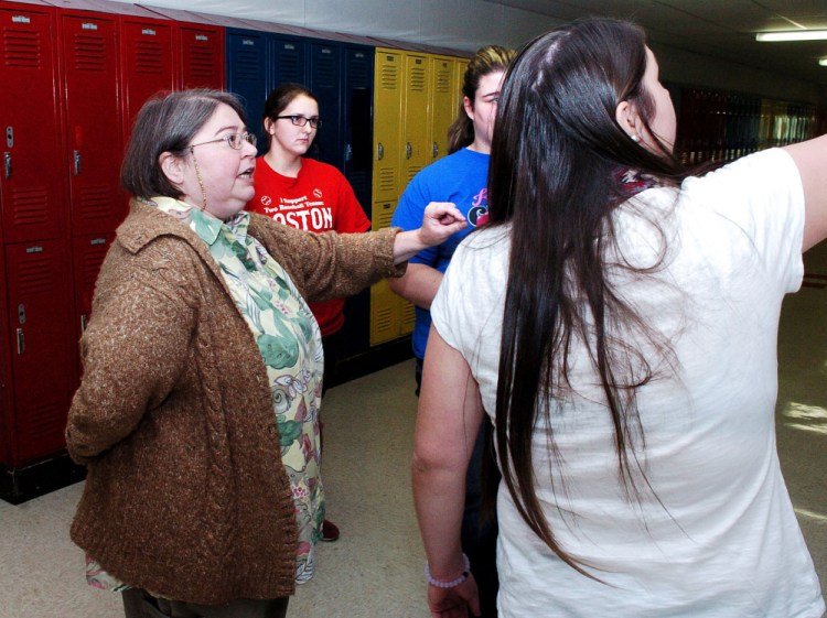 Forest Hills Consolidated School science teacher Kjerstin Winn, left, advises students on a class project at the Jackman school on Thursday. Students from left are Madisen Logston, Dena Bent and Patricia Lessard.