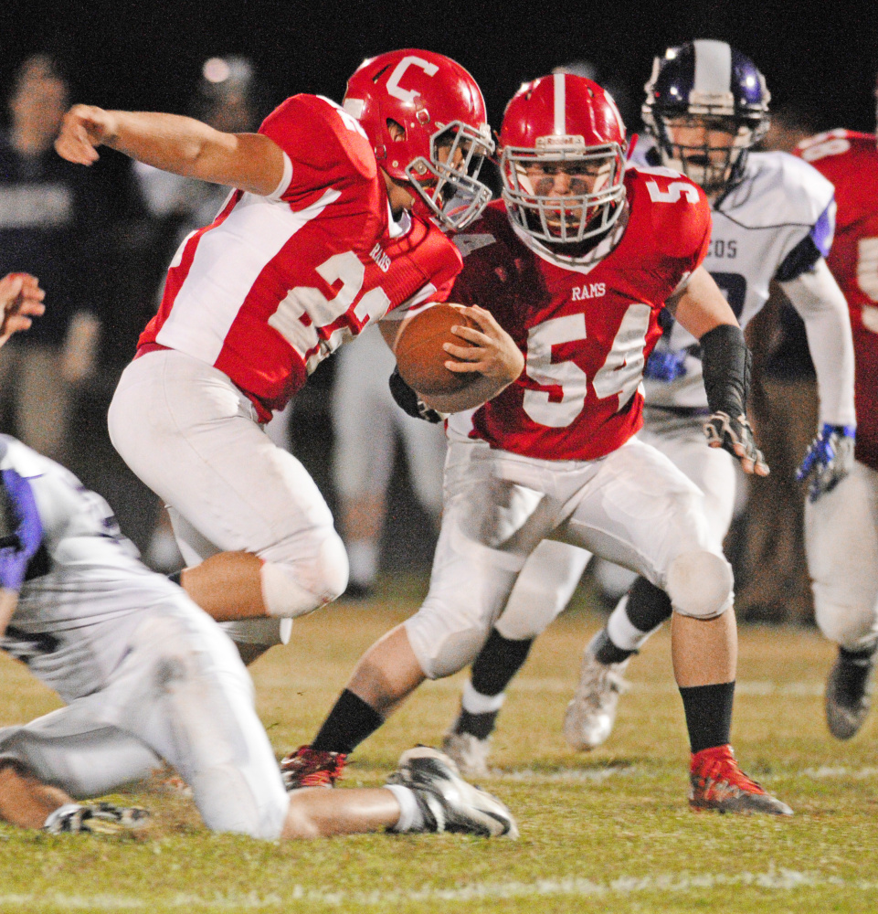 Cony center Sean Cummings (54) looks to clear some space for Chad Bickford during a Pine Tree Conference Class B game last Friday against Hampden at Alumni Field in Augusta.