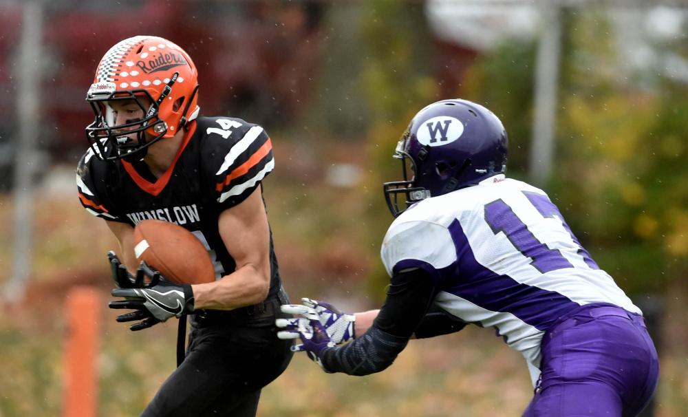 Winslow defender Dylan Hutchinson (14) intercepts a ball intended for Waterville receiver Cooper Hart during a game in Winslow last weekend.