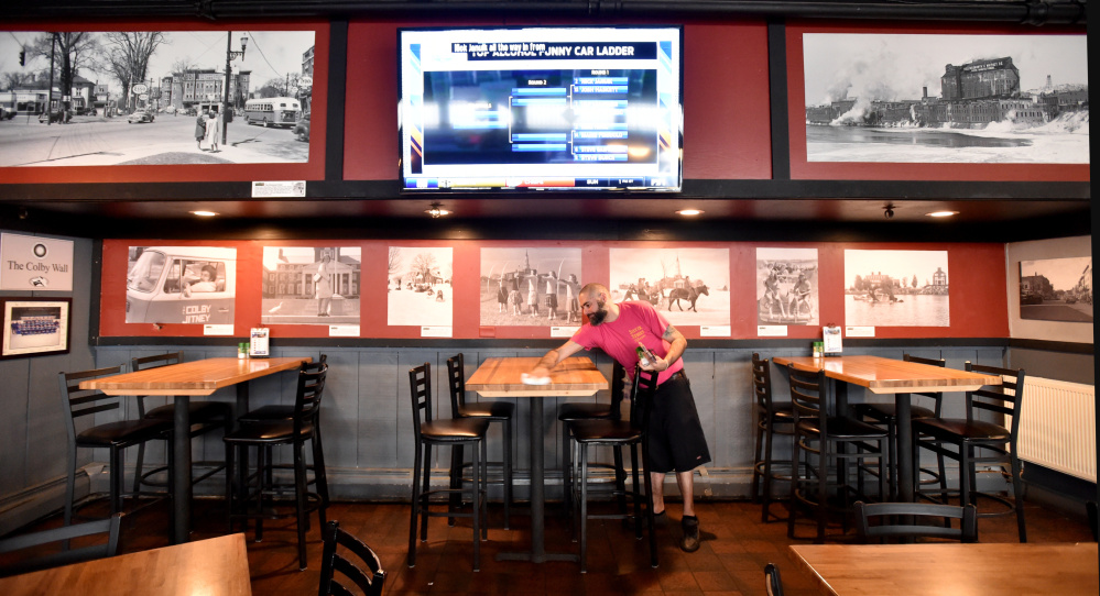 Mike Webber clears tables Friday during his shift at the Silver Street Tavern in Waterville.