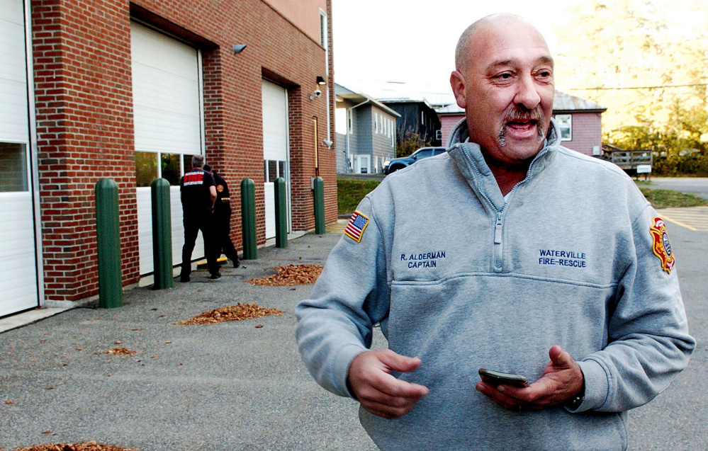 Waterville Fire Capt. Rodney Alderman speaks about following a male suspect who reportedly smashed a window with a pipe in the rear of the department building, background, on Monday.