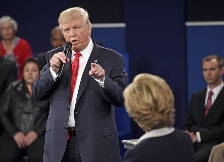 Republican presidential nominee Donald Trump points at Democratic nominee Hillary Clinton as he speaks during the second presidential debate, in St. Louis, Sunday. His "jail" line was one of the most-discussed debate moments on social media during the debate.<em>Saul Loeb/Pool via AP</em>