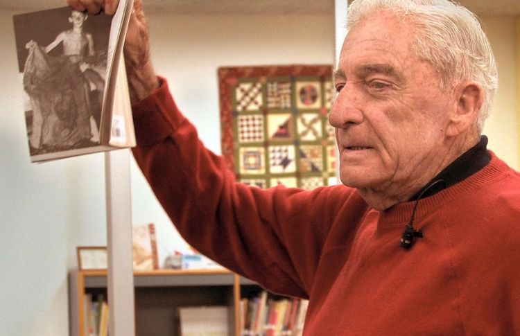 Donn Fendler holds a copy of his book "Lost on a Mountain in Maine." He  frequently visited schools and libraries to talk about his experience and read from his book. Contributed photo