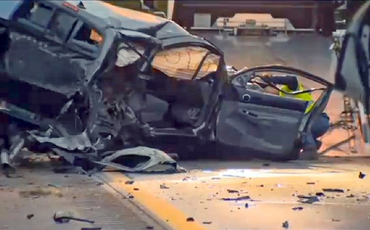 In this still image from video provided by WCAX-TV, a worker attaches a wrecker cable to a vehicle on Interstate 89 early Sunday in Williston, Vt., after a wrong-way driver caused a crash  killing five people, before stealing a police cruiser, striking several vehicles and injuring several people. <em>Via Associated Press</em>