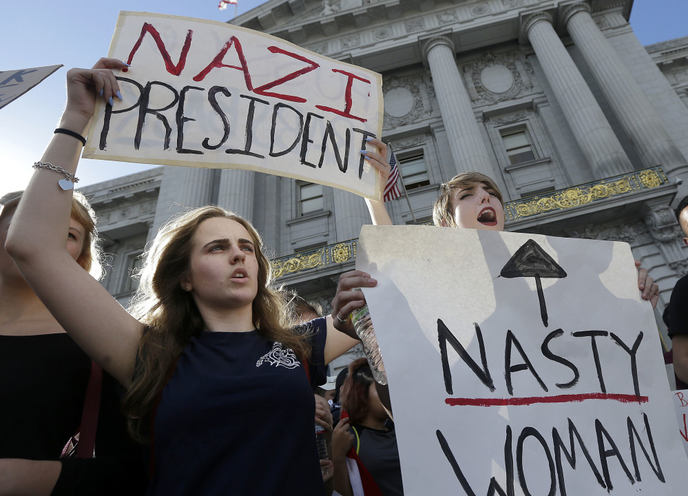 Mission High School students Hope Robertson, left, and Cat Larson yell as they protest with other high school students in front of City Hall in San Francisco on Thursday. They are opposed to Donald Trump's presidential election victory.