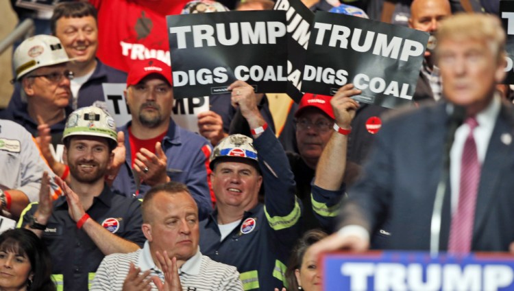 Coal miners wave signs as Republican presidential candidate Donald Trump speaks during a May rally in Charleston, W.Va. Trump's election could signal the end of many of President Obama's signature environmental initiatives.