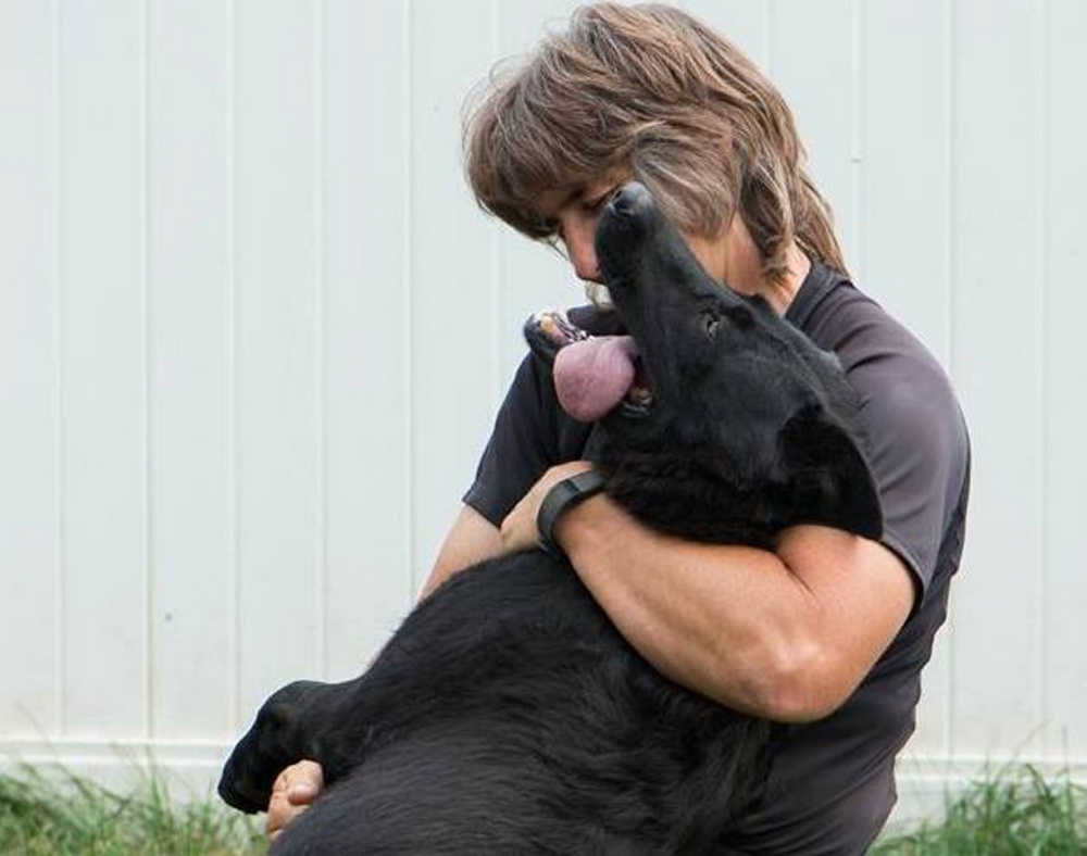 Doreen Metcalf gives Uhdelle a hug. The dog disappeared during a walk in Saco and was found dead in Gray.