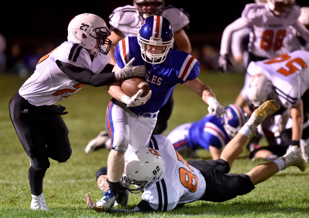 Messalonskee running back Austin Pelletier, center, breaks away from Skowhegan defenders Cooper Holland, left, and Garrett McSweeney during an Oct. 7 game.