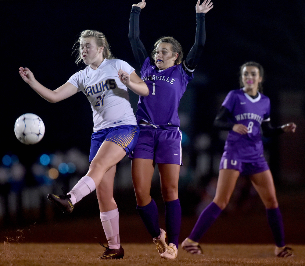 Staff photo by Michael G. Seamans
Waterville's Mackenzie St. Pierre, right, defends Hermon's Maddisyn Curtis (21) during the Class B North championship game Wednesday night in Hermon.