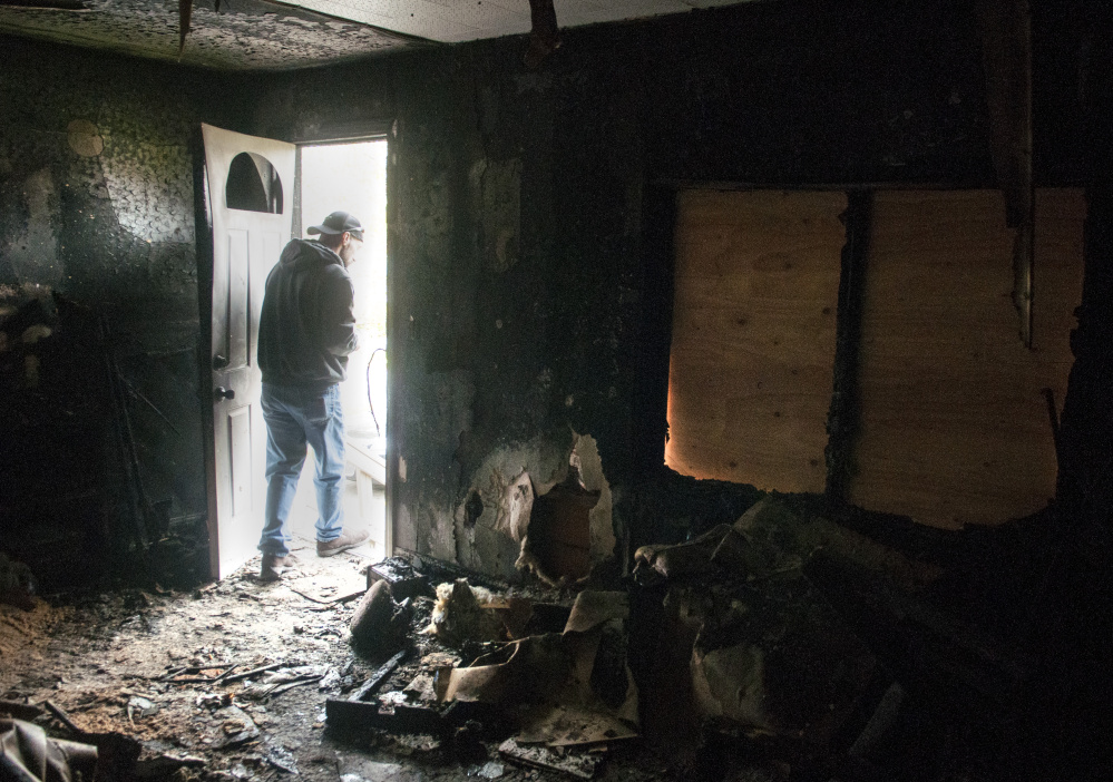 Jeffrey Sansouci walks out the front door of his home Wednesday in Randolph. The home was destroyed by fire on Saturday.