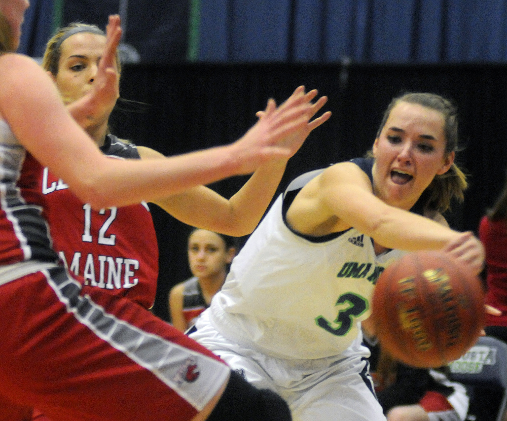 University of Maine at Augusta forward Jamie Plummer passes around Central Maine Community College defenders during a game Thursday night at the Augusta Civic Center