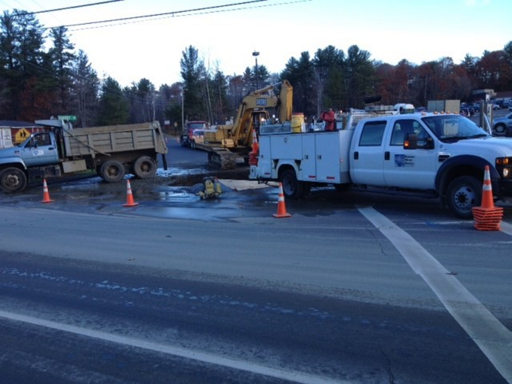 Kennebec Water District workers try to fix a broken water main Friday morning at the entrance to Quarry Road.