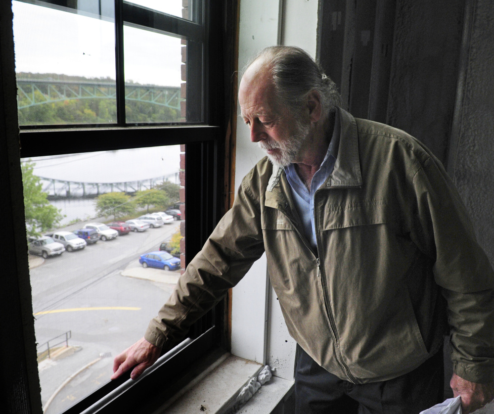 Richard Parkhurst talks about covering old wooden windowsills and frames in aluminum so the replacement windows look the same from the exterior during an October tour of 275-287 Water St. in Augusta.