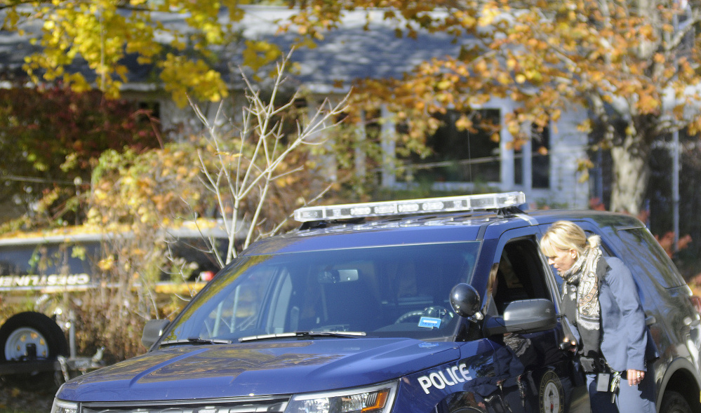 State police Detective Abbe Chabot, right, confers Nov. 1 with Winthrop police Officer Joshua Hammond in the driveway of the Balcer residence in Winthrop, the scene of a double murder in which a 17-year-old is accused of killing his parents.