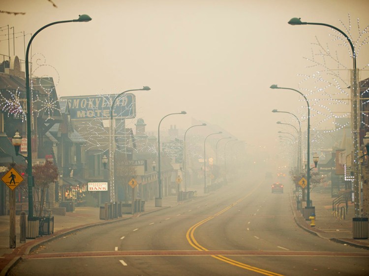 Thick smoke from area forest fires shrouds Gatlinburg, Tenn., Monday. Gatlinburg officials say several areas are being evacuated as a result of fires in and around Great Smoky Mountains National Park. <em>Brianna Paciorka/Knoxville News Sentinel via AP</em>