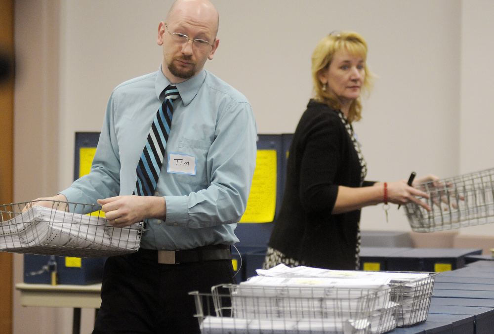 Ballots picked up from Maine communities are taken out of boxes in preparation for the marijuana vote recount, which could take more than a month and cost up to $500,000.