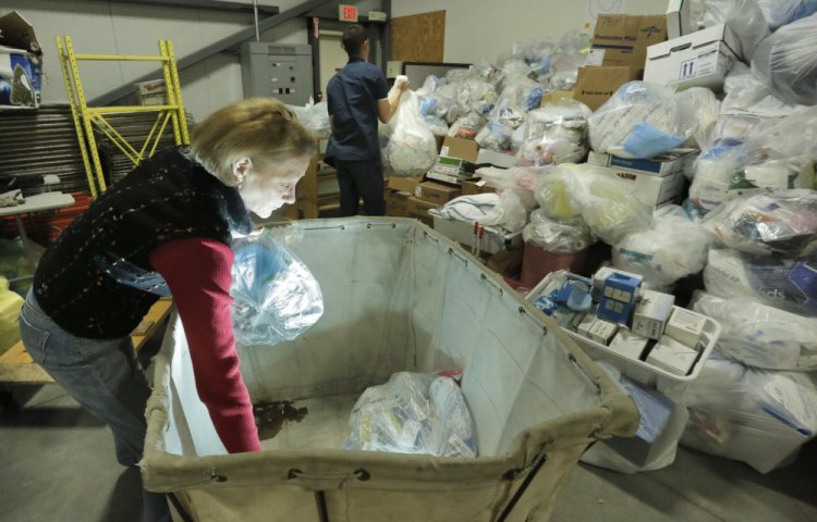 Partners for World Health founder Elizabeth McLellan and volunteer Jimmy Fisette unload bags of medical supplies destined for other countries as the organization moves into a new warehouse in Portland. The group also sponsors six medical missions a year, taking doctors, nurses and students to Southeast Asia and Africa, where they provide medical care.