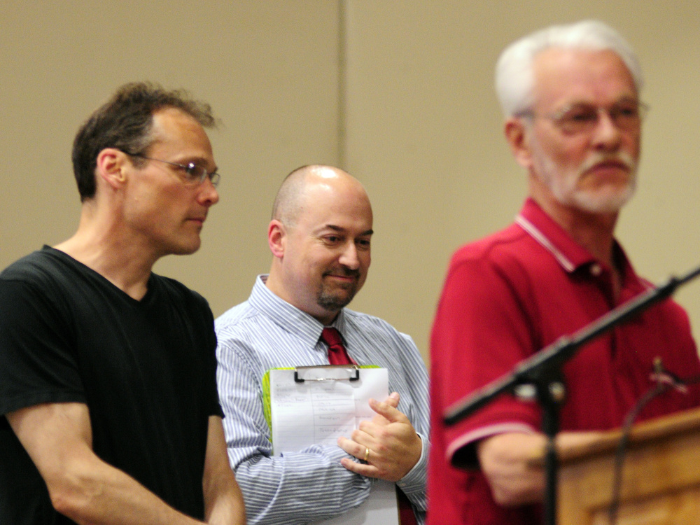 History teacher Shane Gower, center, is framed by Roger Madore, left, and Bob Madore, the grandson and son of Pfc. Harvey Madore, during a May 26 Memorial Day assembly at Maranacook Community School in Readfield.