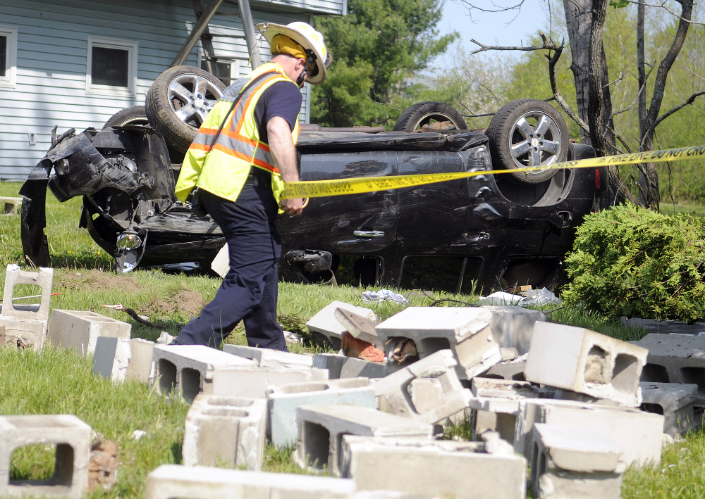 Augusta Fire Department Battalion Chief Steve Leach tapes around a well head May 23 that was struck by a vehicle on Route 3 in Augusta.