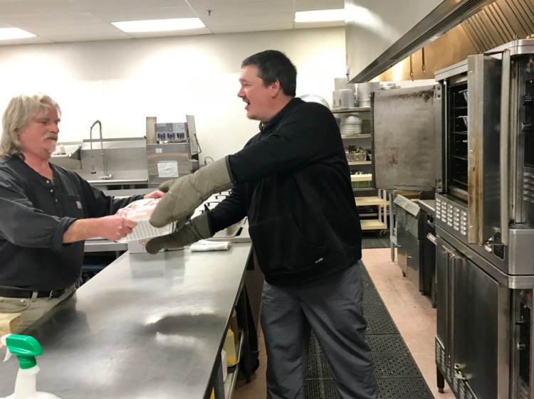Volunteers Rob Spencer, right, and Fred Snyder cook turkeys the kitchen oven Friday afternoon at the Waterville Elks Lodge, where the 10th annual Central Maine Family Christmas Dinner will be held Sunday.
