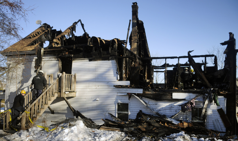 Investigators from the Office of Maine State Fire Marshal examine Sunday the remnants of a building that burned in Richmond on Sunday.