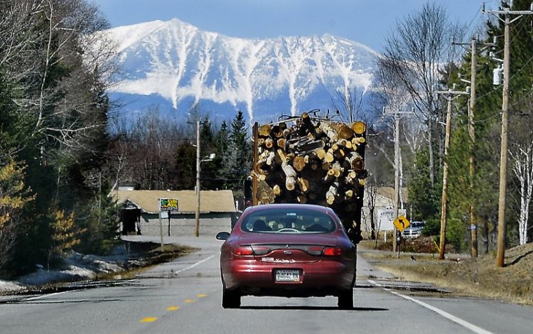 Mount Katahdin looms in the distance as a truck carries logs to a logging yard in Millinocket in 2014. On Saturday, close to 1,000 runners are expected for an unusual road race that aims to help the struggling mill town.