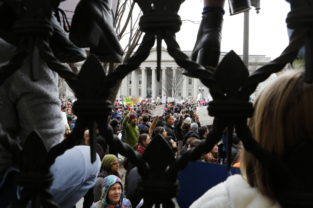 Demonstrators near the White House held poster boards with messages such as "Dissent is patriotic" and "Islamophobia is un-American" while singing "This Land is Your Land."