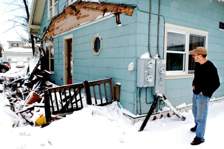 Homeowner Richard Faeth surveys the crumbled remains of the porch Wednesday at his home on Fairbanks Road in Farmington, after a large truck went out of control during a Tuesday evening storm and hit his house.