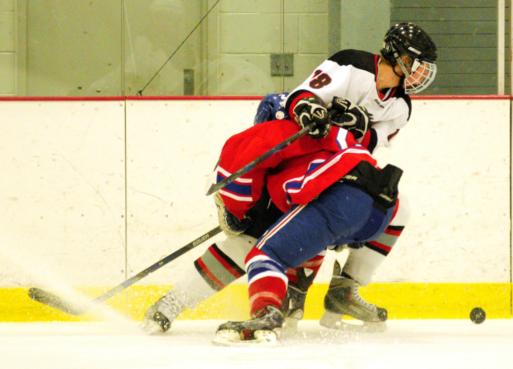 Messalonskee's Dana Michaud, bottom, and Maranacook/Winthrop's Matt Ingram battle for the puck Wednesday at Bonnefond Ice Arena in Kents Hill.
