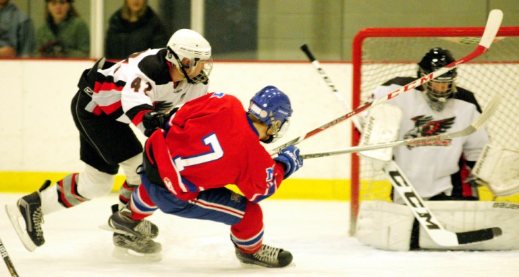 Maranacook/Winthrop's Dan Shea (42) pushes Messalonskee's Tyler Lewis as he shoots and misses on the Hawks keeper Will Hayes during a game Wednesday at Bonnefond Ice Arena in Kents Hill.