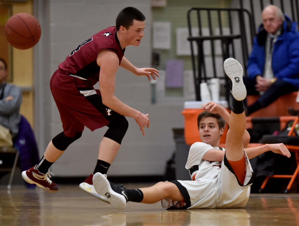 Winslow's Spencer Miranda tries to pass the ball from the court as Maine Central Institute's Owen Williams, left, defends during a Class B game earlier this season in Winslow.