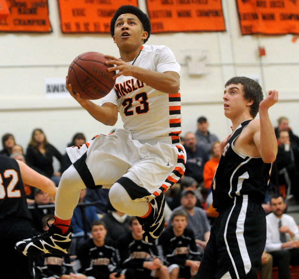 Winslow High School's Keanu Earle left, draws a foul from a Gardiner defender during the first half of a Kennebec Valley Athletic Conference Class B game last season.